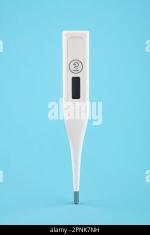 Digital thermometer levitating on a blue background. Stock Photo