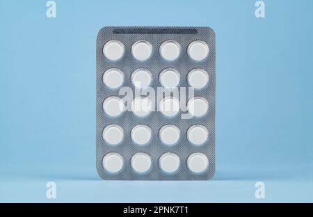 Blister of tablets on a light blue background. Stock Photo