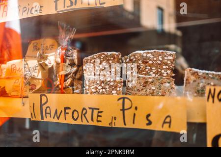 Pisa, Italy - March 18, 2023:Panforte in festive paper packaging for sale on the counter of a shop window. High quality photo Stock Photo