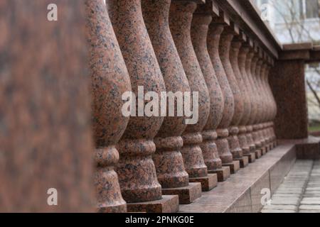 Stone balusters made of pink granite, marble close-up, selective focus. Stock Photo