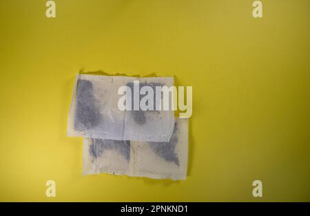 two pairs of square tea bags isolated on a yellow background Stock Photo
