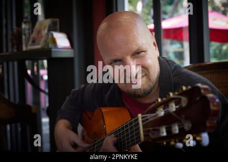 Handsome guy showcases musical talent with acoustic guitar at show Stock Photo