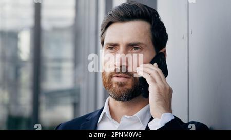Portrait serious man talking on mobile phone answering business call successful businessman professional manager agent consultant communicate remote Stock Photo