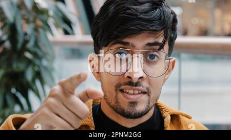 Close-up Indian bearded man pointing index finger at camera young confident arabian guy make choosing gesture showing direction muslim male Stock Photo