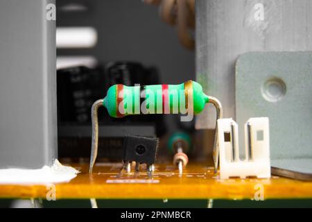 Carbon film resistor with a green color on electronics circuit board of electric appliance, Electronics part concept. Stock Photo