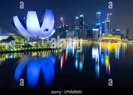 A night view of Marina Bay in Singapore, including the lotus-shaped ArtScience Museum and the business district's highrise skyline. Stock Photo