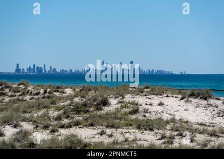 View across the water from sand dunes at Kirra Beach to the skyline of Surfers Paradise. Gold Coast, Queensland, Australia Stock Photo