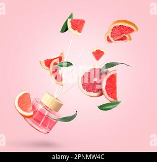 Reed diffuser with grapefruit slices on pink background Stock Photo