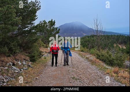 Senior couple hiking down the gravel road in Croatia Stock Photo