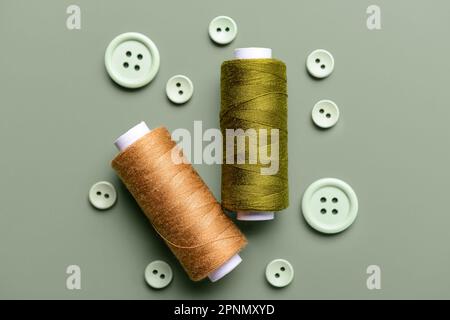 Composition with thread spools and buttons on grey background Stock Photo
