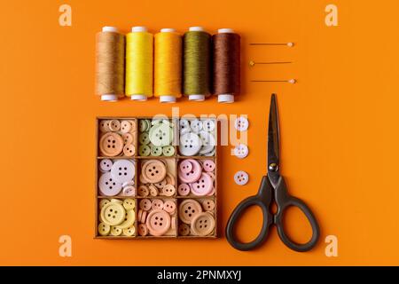 Composition with different thread spools and sewing supplies on color background Stock Photo