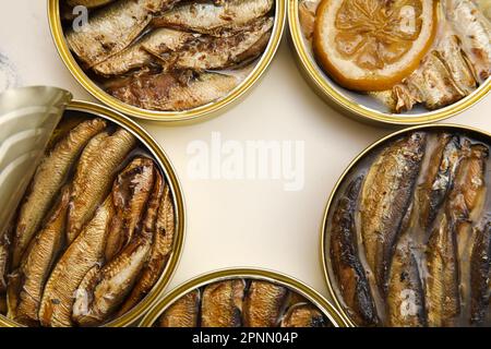 Opened tin cans with sprats in oil on white table Stock Photo