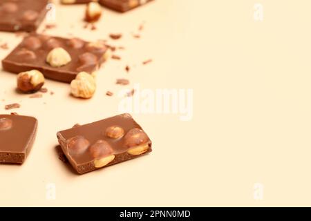 Sweet tasty chocolate with nuts on  beige background Stock Photo