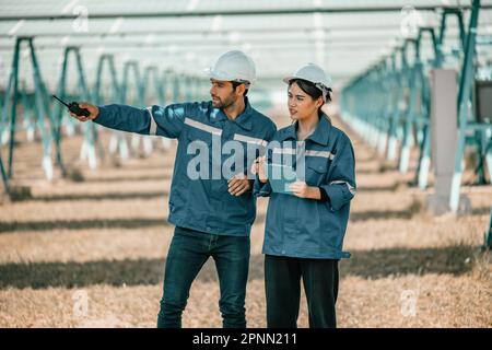 Solar design engineers visually inspect photovoltaic array installation ...