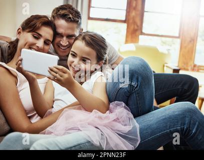 Simple moments can make for the best memories. a little girl taking a selfie with her parents at home. Stock Photo