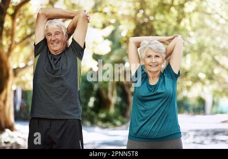 Its important to keep active as you age. a senior couple warming up before a run outside. Stock Photo