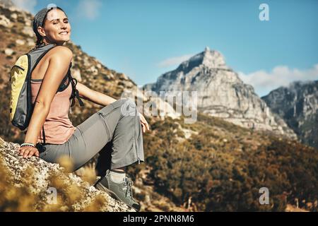 Theres no better way to spend your free time. Portrait of a young woman taking a break while out on a hike through the mountains. Stock Photo
