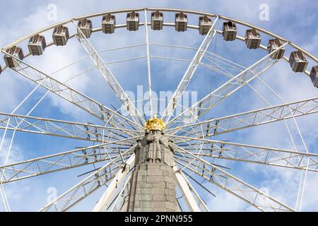 Ferris wheel installed on Place Poelaert in Brussels. War memorial in the foreground. Stock Photo