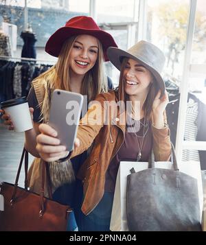 Shopping and selfies. two young girlfriends snapping selfies while