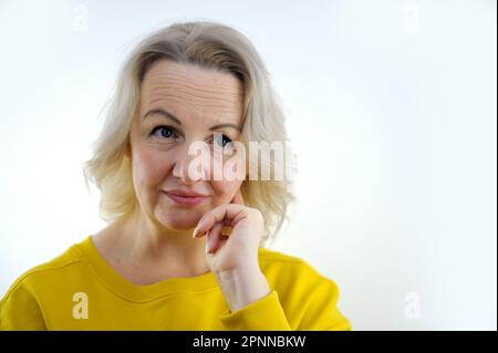 Closeup photo of amazing short hairdo lady looking up empty space deep thinking creative person arm on chin wear casual green turtleneck isolated yellow color background. High quality photo Stock Photo