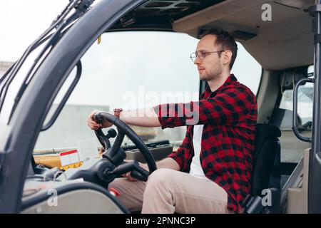 Young Rural Tractor or Combine driver sitting in the cab. Farming and harvesting. Farming and harvesting Stock Photo