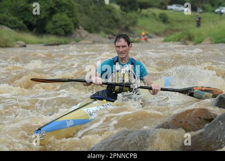 Fit older man paddling boat, senior competitor Dusi Canoe Marathon 2023, Durban, South Africa, active mature male, adventure sport, canoeing race Stock Photo