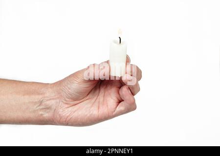 Men's hand holding a candle isolated white background. Man holding burning candle, closeup Stock Photo
