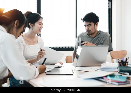 Diverse colleagues working on project together. Diverse Team of Creative Professionals Talk, Brainstorms Stock Photo