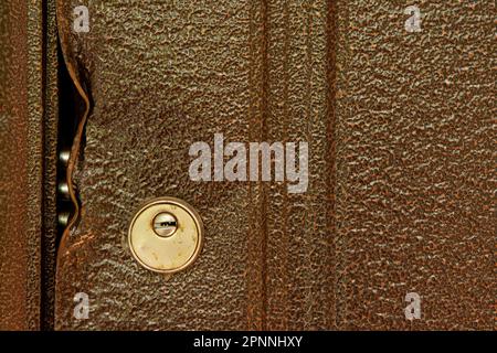 large durable lock is broken in a metal door close-up. Damaged door lock in a country house Stock Photo