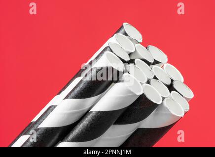 https://l450v.alamy.com/450v/2pnnj1m/striped-black-and-white-straws-on-red-background-2pnnj1m.jpg