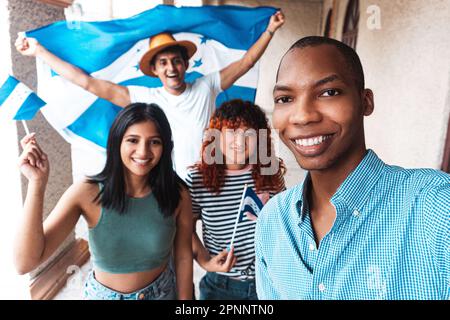 Multiracial group of friends taking a selfie celebrating the independence of Honduras. Stock Photo