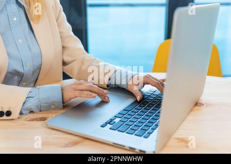 Close up shot businesswoman hands using laptop computer typing on keyboard, searching information, browsing. Female student on manager internship Stock Photo