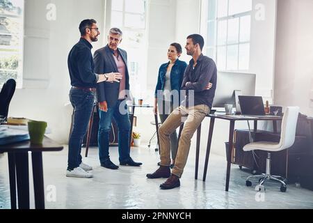 Building an effective team doesnt have to be a challenge. a group of designers having a discussion at work. Stock Photo