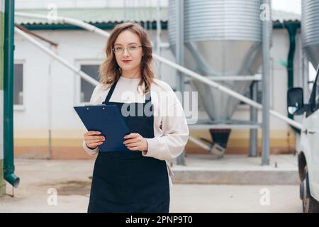 Woman Agricultural Engineer with Documents Near Cyclone Industrial Equipment Stock Photo