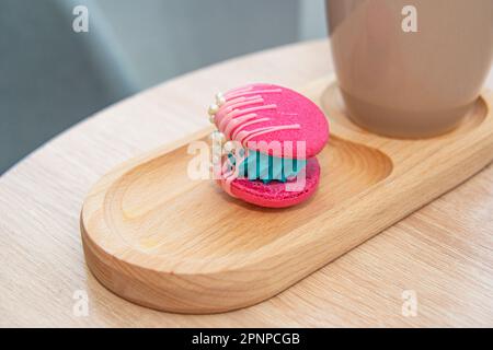 cup of coffee latte and colorful pink macaroons on wooden table Stock Photo
