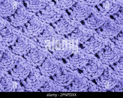 Purple Knitting pattern close-up. Knitting is an easy pattern for beginners. Texture of a knitted sweater. Warm thread pattern in the shape of a fan Stock Photo