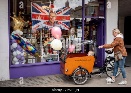 With two weeks before the coronation of King Charles III takes place, a mother prepares to cycle away with party balloons attached to her cargo bike after buying them from a party and balloon business selling royal merchandise, on 19th April 2023, in London, England. King Charles will succeed Queen Elizabeth II on 6th May, who passed away last year. Stock Photo