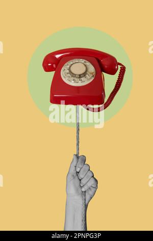 a man hand in black and white pulling a rope with a red rotary dial telephone in its end, in a green circle, on a yellow background Stock Photo