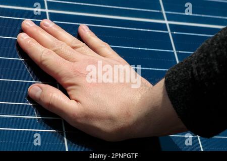 Solar panel cells close up and hand. - alternative energy. Stock Photo