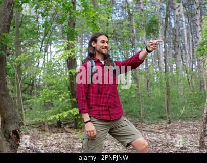 Long hair man walking in forest Stock Photo