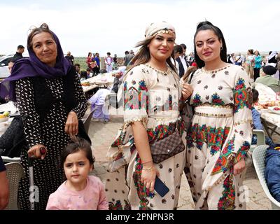 Two young women and their mothers in traditional clothes participate in the Red Wednesday holiday celebration in Bacinê village. Yazidi Kurds living in the Bacine village of Midyat district and Besiri districts in Turkey celebrated the Red Wednesday holiday, known as 'Charshema Sor' in Kurdish, joyfully with various entertainments. Men, women and children of 10 Yazidi families living in the village of Bacine gathered at the Yazidi Cultural Center after morning prayers, wearing the most colorful and beautiful dresses. Yazidis believe that April is a holy spring month and that the world was crea Stock Photo