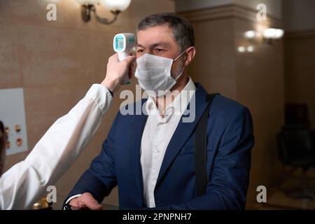 Portrait of male came to hotel, checking temperature Stock Photo