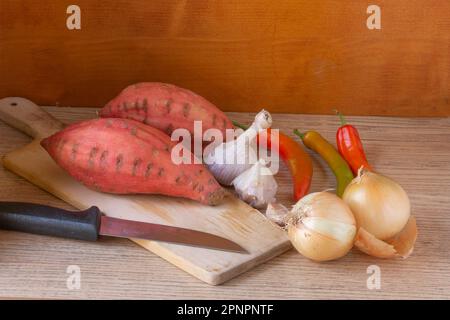 Still life of vegetables and sweet potatoes on a cutting board Stock Photo