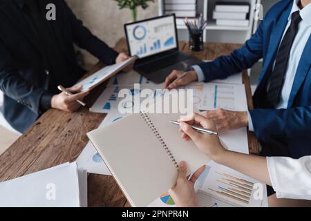 Business team discussing working analyzing with financial data and marketing growth report graph in team, presentation on laptop in office Stock Photo