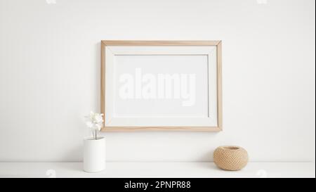 Light wooden frame for pictures with rectangular horizontal shape on white wall with decoration elements and shelf mockup template Stock Photo