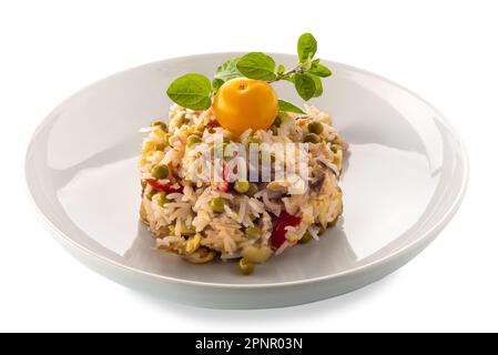 Rice salad with vegetables and tomatoes and peas with yellow cherry tomato and sprig of marjoram in white plate, isolated on white with clipping path Stock Photo