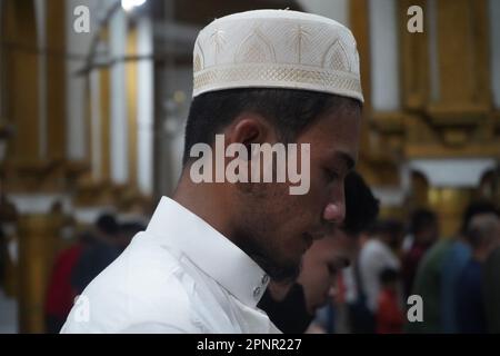 Quiapo, Philippines. 20th April, 2023. Muslims of Quiapo, Manila attends the first night prayer before Eid al-Fitr. There will be no taraweeh prayers on this last night of Ramadan, but a devout Muslim will spend the night in prayer, remembrance of Allah and reading the Quran because this evening is regarded as a very blessed night and Muslims believe that it should be spent in nafl (voluntary) salat (prayers) and worship. (Credit Image: © Sherbien Dacalanio/Alamy Live News) Stock Photo