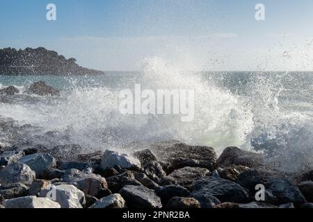 Wave splashing against rocks on the beach in Golfo dei Poeti (Gulf of Poets), Lerici, La Spezia, Liguria, Italy Stock Photo