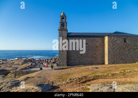 Muxia, A Coruna - Spain; August 30, 2022: Virxe de la Barca Sanctuary on Atlantic coast rocks in the foreground afternoon light Stock Photo