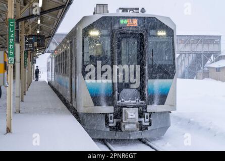 A JR East GV-E400 series train on a snowy day at Goshogawara Station in Aomori Prefecture, Japan. Stock Photo